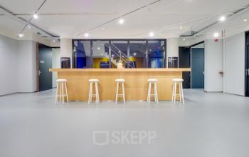 Modern office space at Europalaan 500 in Utrecht Kanaleneiland featuring a sleek, open floorplan with a light-colored bar counter and stools. Ideal for businesses seeking office space rental.