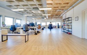 Spacious modern office to rent at Europalaan 101, Utrecht Kanaleneiland, featuring an open floor plan with desks, chairs, and shelving units.