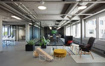 Modern open floor plan at Europalaan 101, Utrecht Kanaleneiland, features glass partitioned workspaces and a stylish lounge area, ideal for office space rental.