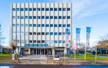 Exterior view of the office building at Europalaan 101, Utrecht Kanaleneiland, suitable for office space rental. The modern structure features large windows and a well-maintained garden area in front.