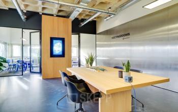 Modern meeting area at Europalaan 101, Utrecht Kanaleneiland, featuring a sleek wooden table and innovative decor, ideal for office space rental.