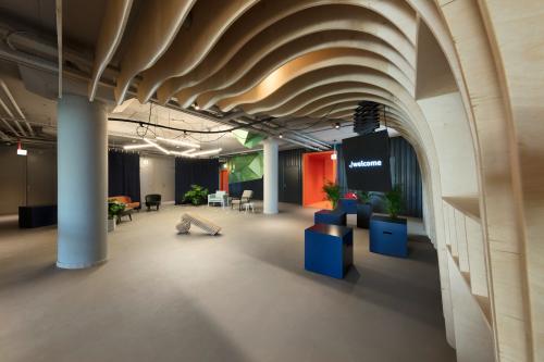 Modern office space with unique ceiling design at Europalaan 101, Utrecht. Features welcoming seating area and open layout ideal for office space rental.