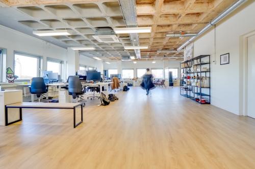 Spacious modern office to rent at Europalaan 101, Utrecht Kanaleneiland, featuring an open floor plan with desks, chairs, and shelving units.