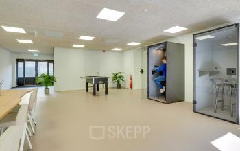 Modern office space at Europalaan 93 Utrecht Kanaleneiland, featuring open work booths, seating area, and a table tennis setup, suitable for office space rental.