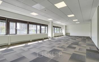 Bright office space rental at Europalaan 93 in Utrecht Kanaleneiland with large windows and patterned carpet, offering a spacious and versatile layout ideal for various business activities.