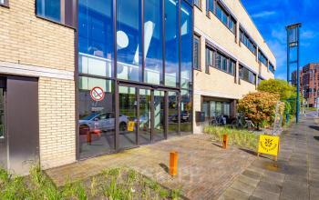 Exterior view of Europalaan 93 in Utrecht Kanaleneiland, showcasing a modern office building with large glass windows and a landscaped entrance, perfect for office space rental in a vibrant business area.