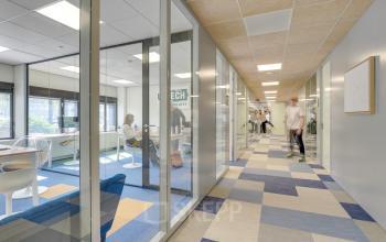 Modern and well-lit office space rental at Europalaan 93, Utrecht Kanaleneiland with glass-walled meeting rooms and professionals engaged in collaborative work.