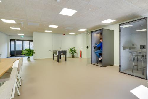 Modern office space at Europalaan 93 Utrecht Kanaleneiland, featuring open work booths, seating area, and a table tennis setup, suitable for office space rental.