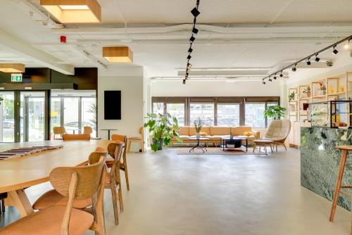 Bright and modern office space in Utrecht Kanaleneiland with stylish furniture, wooden tables, and large windows. Ideal for office space rental, this inviting workplace offers a relaxed ambiance and ample natural light.
