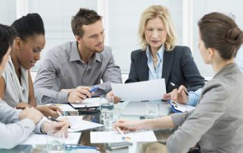 Employees collaborating in a modern office setting at Atoomweg 280-282, Utrecht Lage Weide, Utrecht, with documents and laptops on the table.