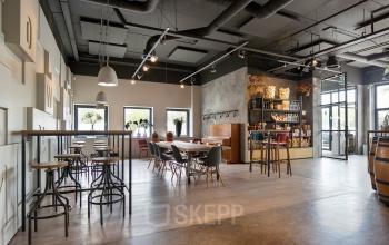 Spacious, modern office space at Atoomweg 63, Utrecht Lage Weide, featuring a mix of high tables and cozy seating. Ideal for office space rental.