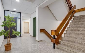Office space at Zonnebaan 45, Utrecht Lage Weide, featuring a staircase and hallway with a potted plant, ideal for business activities. Rent office space in a welcoming environment.