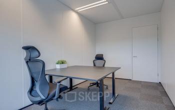 Furnished interior office space at Zonnebaan 45, featuring two chairs and a desk, ideal for office space rental in Utrecht Lage Weide.