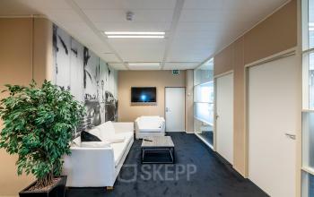 Furnished office space at Zonnebaan 45, Utrecht Lage Weide, featuring a cozy lounge with white sofas and a wooden table, ideal for those seeking office space rental.