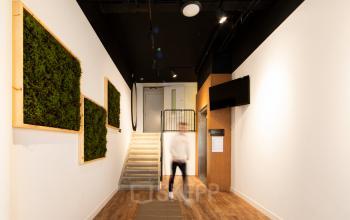 Interior view of Middenburcht 136 office to rent, featuring a staircase, wall-mounted greenery, modern lighting, and wooden flooring in Utrecht Leidsche Rijn, Utrecht.