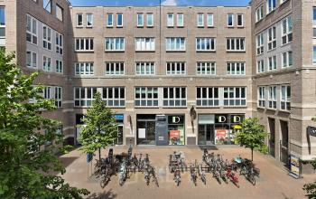 Front view of the office building at Middenburcht 136, Utrecht Leidsche Rijn, with a bicycle parking area in front.