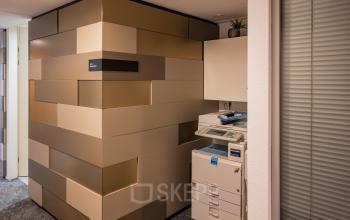 Printer area in the office space at Middenburcht 136, Utrecht Leidsche Rijn with modern, geometric wall design and cabinetry.