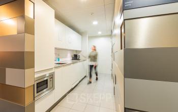 Pantry area in an office building located at Middenburcht 136, Utrecht Leidsche Rijn, Utrecht, with a microwave, sink, and storage cabinets.