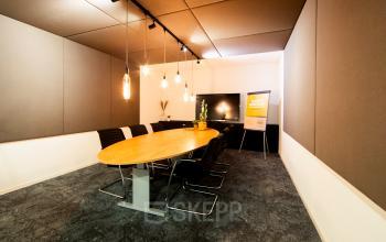 Conference room at Middenburcht 136, Utrecht Leidsche Rijn, featuring a large table, chairs, and modern lighting, ideal for office space rental.