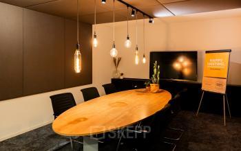 Cozy meeting room at Middenburcht 136, Utrecht Leidsche Rijn, featuring a wooden table and modern chairs, perfect for office space rental discussions.