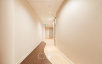 Interior hallway of office space at Middenburcht 136, Utrecht Leidsche Rijn, featuring a curved design and modern lighting.