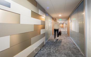 Modern office corridor at Middenburcht 136, Utrecht Leidsche Rijn, with a sleek design and glass partitioned offices for rent.