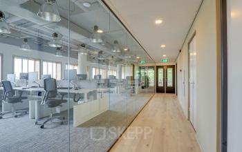 Modern office space with glass partitions at Goeman Borgesiuslaan 77 in Utrecht North, featuring multiple workstations and ergonomic chairs.