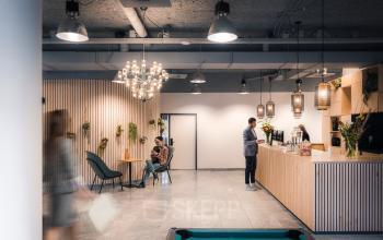 Modern office lounge at Goeman Borgesiuslaan 77, Utrecht North. Featuring comfortable seating, a coffee bar, and decorative lighting, ideal for office space rental.