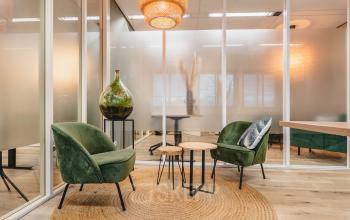 Chic office space available for rental at Goeman Borgesiuslaan 77, Utrecht North. Stylish interior with modern seating and warm lighting, perfect for creative meetings or client discussions.