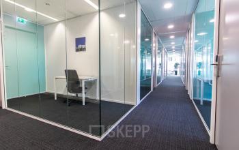 Modern office space rental available at Papendorpseweg 95-97, Utrecht Papendorp, featuring glass-walled rooms and a sleek, furnished interior.