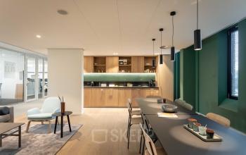 Modern office space for rent at Van Deventerlaan 31-51, Utrecht Papendorp, featuring a stylish interior with sleek furnishings, a long table, and a cozy seating area.