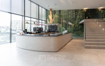 Bright office space with large windows, modern design featuring a reception area with a counter, located at Van Deventerlaan 31-51 in Utrecht Papendorp. Ideal for office space rental.