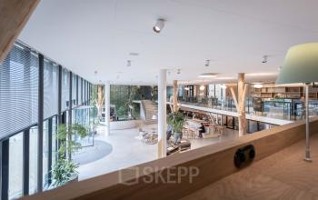 Spacious office space in Utrecht Papendorp with modern furnishings, featuring open workspaces and a loft area with business activity.