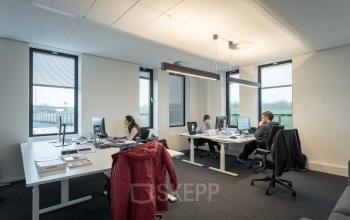Modern office space in Utrecht Papendorp with desks and computers, featuring employees working on computers.
