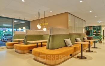 A well-lit, furnished workspace at Van Deventerlaan 30-40, Utrecht Papendorp, ideal for office space rental with stylish seating and modern decor.