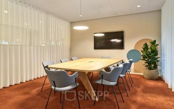 Modern conference room available for office space rental at Van Deventerlaan 30-40, Utrecht Papendorp, featuring a large wooden table and stylish chairs.