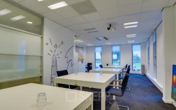 Modern office space rental at Orteliuslaan 850, Utrecht Papendorp, with white desks, bright artwork, and large windows.