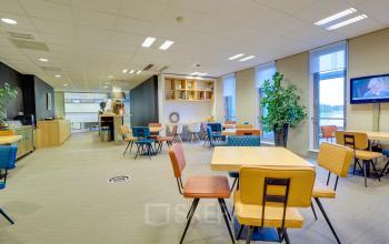Modern office space rental at Orteliuslaan 850, Utrecht Papendorp, featuring a well-equipped lounge area with stylish furniture and ample lighting.