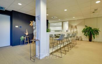 Modern office space rental at Orteliuslaan 850, Utrecht Papendorp, featuring stylish high stools and communal bar table for collaborative work.