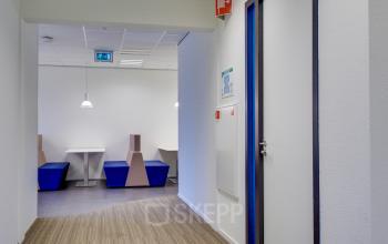 Modern office space rental at Orteliuslaan 850, Utrecht Papendorp featuring a neatly organized interior with white tables and blue chairs.