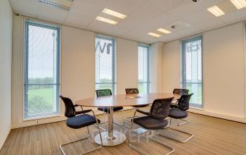 Modern conference room with a round table and chairs for office space rental at Orteliuslaan 850, Utrecht Papendorp.