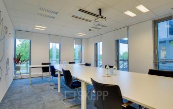 Modern office space rental at Orteliuslaan 850, Utrecht Papendorp, featuring a well-lit conference room with large windows and contemporary furniture.