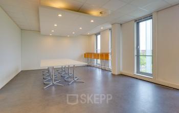 Modern office space rental at Orteliuslaan 850, Utrecht Papendorp with a well-lit interior, large windows, and minimalist furnishing.