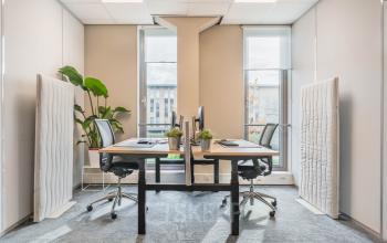 Modern office space rental in Utrecht Papendorp with large windows, two desks, and ergonomic chairs, enhancing a bright and inviting atmosphere for productivity.