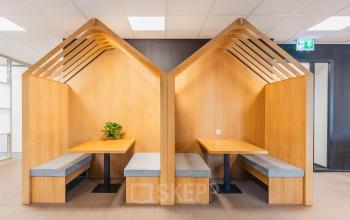Modern office space rental featuring wooden booth seating at Orteliuslaan 850, Utrecht Papendorp, ideal for collaborative work. Perfect office to rent for dynamic teams.