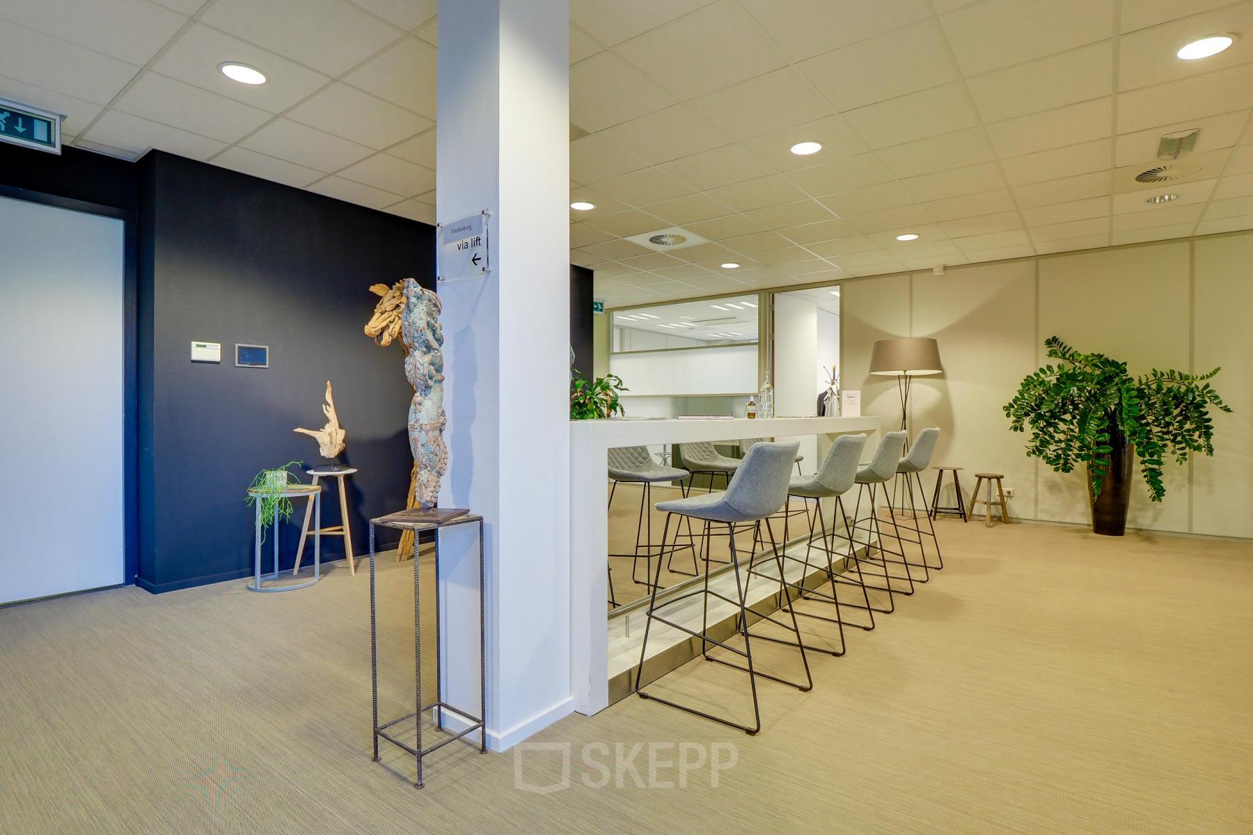 Modern office space rental at Orteliuslaan 850, Utrecht Papendorp, featuring stylish high stools and communal bar table for collaborative work.