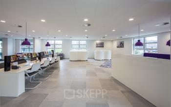 Modern office space at Newtonlaan 115 in Utrecht Rijnsweerd, featuring open workspaces with desks, chairs, and purple pendant lighting.