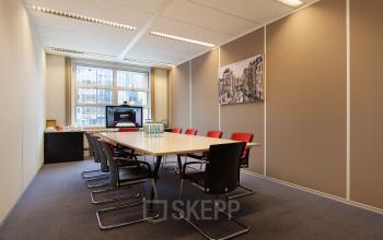 Conference room at Newtonlaan 115 in Utrecht Rijnsweerd, featuring a long table, chairs, a cabinet, and a wall-mounted picture.