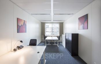 Office space rental at Newtonlaan 115, Utrecht Rijnsweerd, featuring modern desks, chairs, and abstract wall art in a well-lit room.
