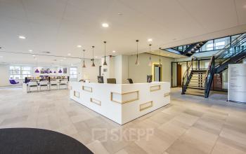 Modern, well-lit reception area with a white desk and seating at Newtonlaan 115 in Utrecht Rijnsweerd, suitable for office space rental.